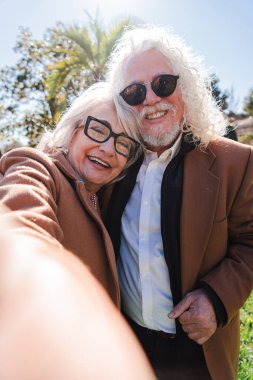 Büyüleyici son sınıf çifti, neşeli bir selfie anının keyfini çıkarırken, neşeli ilişkilerini gösterirken mutluluk ve şefkat yayıyorlar, hayatlarındaki sevgi ve bağın özünü somutlaştırıyorlar.