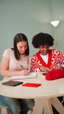 Enerjik bir şekilde bilgi alışverişinde bulunan, notlar alan ve birbirlerini hevesle destekleyen iki öğrencinin bulunduğu canlı ve dinamik bir çalışma oturumu.