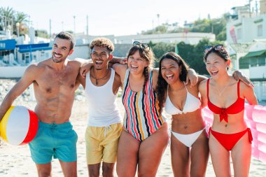 Bir grup neşeli arkadaş plajda eğleniyorlar, etrafları güneş ışığı ve dalgalarla çevrili bir plaj topuyla oynarken. Unutulmaz yaz anıları yarattıklarında kahkahaları havayı doldurur.