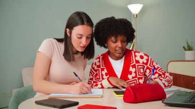 Enerjik bir şekilde bilgi alışverişinde bulunan, notlar alan ve birbirlerini hevesle destekleyen iki öğrencinin bulunduğu canlı ve dinamik bir çalışma oturumu.