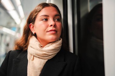 Trene binen düşünceli bir bayan yolcu. Gününü ve etrafını yansıtırken trenin penceresinin yanında durup bir anlık tefekkür yaratıyor.