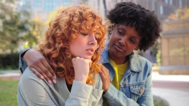 İki kadın, bir arkadaşın diğerine teselli ve empati sunduğu, duygusal sıkıntı ve üzüntü yaşayan, dostluğun ve desteğin önemini gösteren, destekleyici bir an yaşar..