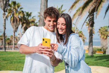 Neşeli çift akıllı telefonlarını karıştırıyor, gülüşlerini ve keyifli anlarını paylaşıyorlar..