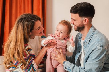 Sevgi dolu ebeveynler ve sevimli bebekleri arasında neşe dolu bir bağ olduğunu gösteren neşeli aile etkileşimleri kahkahalar ve şefkatle dolu, birlikte uzun süreli anılar yaratıyor..