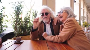 Sevimli yaşlı bir çift akıllı bir telefonla mutlu mesut takılıyor, kahkahalarla gülüyor ve kahkahalarla kahkahalarla kahkahalarla kahkahalar atıyorlar. Keyifli kahalar atıyorlar.