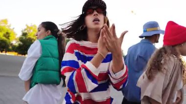 Enerjik dans figürlerini sergileyen dinamik bir arkadaş grubu, neşe ve coşku dolu, birlikte geçirdikleri zamanın keyfini çıkarırken bulaşıcı bir hava yaratıyorlar..