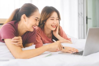 İlişki konseptiyle birlikte yaşayan iki yetişkin kadın. Doğru kişiye odaklan. Güneydoğu Asyalıların dostluğu yatak odasında uzanıyor ve sabahları iş hakkında konuşuyor..