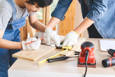 Southeast asian family father and son diy or repair at home concept. Dad teach using tools about carpenter or engineer education skill with child at workshop.