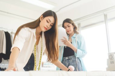 People tailor working in fashion design concept. Young adult asian woman designer making clothes for business start up studio dressmaker.