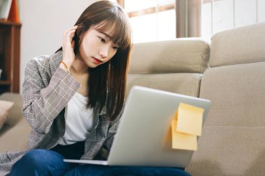 Asia student study online stay at home for new normal from virus concept. Asian teenager woman learning via internet technology with laptop. Living room background with window light.