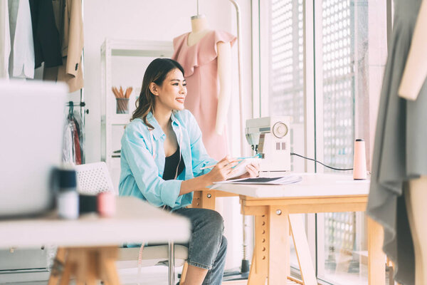 Люди работают в концепции fashion-дизайна. Молодая азиатская женщина дизайнер шьет одежду для бизнес-стартап студия портнихи.