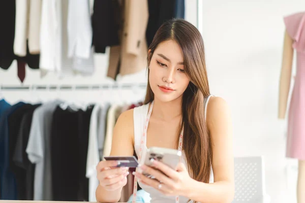People shopping via online application and digital wallet concept. Beutiful southeast young adult asian woman consumer using creadit card and smartphone.
