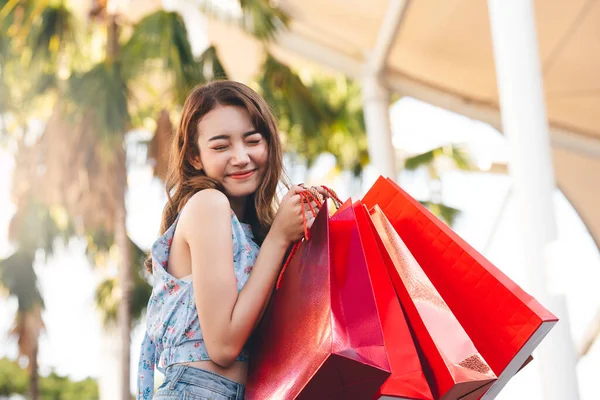 休日には単一のお店のライフスタイルの幸福 ショッピングバッグ付き幸せな若い大人のアジアの女性 日のデパートで — ストック写真