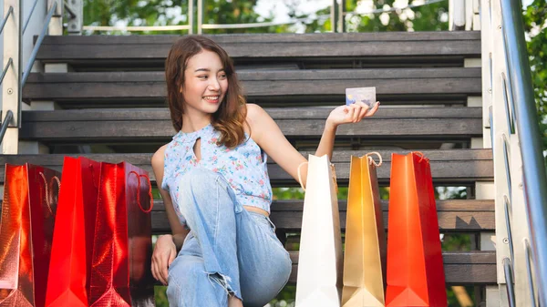 休日の独身生活をしている 若い大人アジア女性保持クレジットカードとショッピングバッグ キャッシュレス コンセプトによる購入 — ストック写真