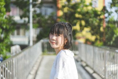 Portrait of young adult asian business woman looking camera. At outdoor under sunlight background with copy space.