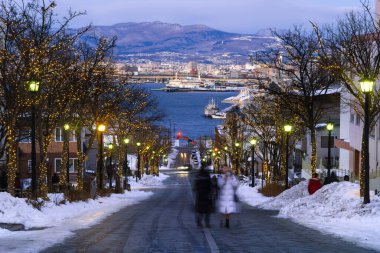 Hachimanzaka famous romantic destination of tourist and traveller on winter. On sunset with city background. Hakodate, Hokkaido, Japan.