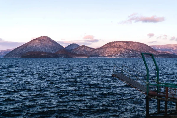 Toya lake with soft morning sunrise view at Toyako town. Yotei mountain on background. Hokkaido, Japan.