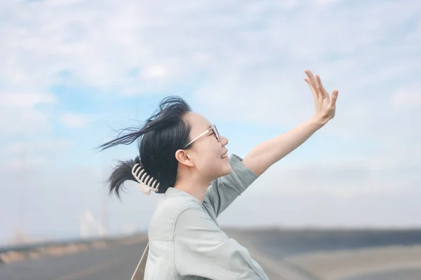 幸せな笑顔で若い大人のアジアの女性側のビューの肖像画 日本のムードトーン写真 青空と道路の背景 — ストック写真