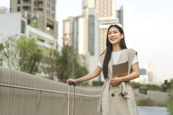 带着旅行行李和商务旅行数码平板电脑的亚洲年轻成年女性 美丽的微笑面对长发 城市生活方式的人在白天 城市背景 — 图库照片