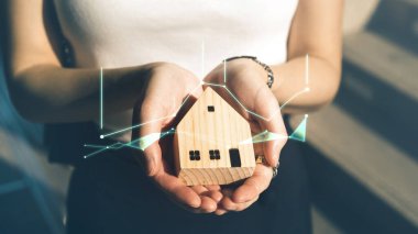 İş kadını el ele tutuşan dijital finans büyüyen yeşil grafiği olan ev modeli. Emlak yatırımı ve siber sigorta kavramı. 