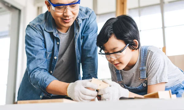 stock image Southeast asian family father and son diy or repair at home concept. Dad teach using tools about carpenter or engineer education skill with child at workshop. Activity homeschooling.