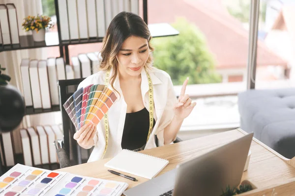People tailor working in fashion design concept. Young adult southeast asian woman designer teach online to student study via internet digital technology.