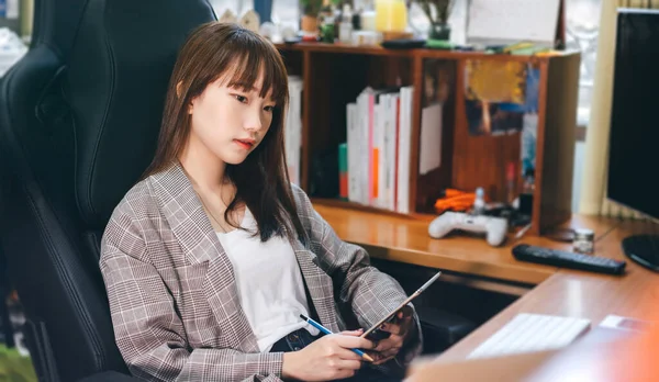 College student study online and stay at home for new normal concept. Asian teenager relax woman using tablet technology for work and education.