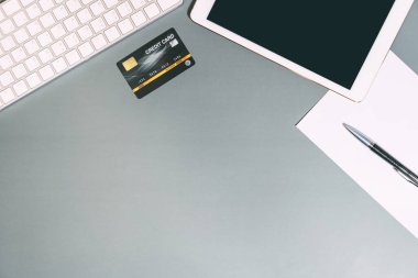 Dijital aletli ofis masasının üst görüntüsü. Gri fotokopi alanı ile kredi kartını düzenle. Modern yaşam tarzı ekipman düz açı konsepti.