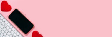 Online flört uygulaması konsepti. Kırmızı kalpli akıllı telefon ve fotokopi alanı için klavye boş ekran. Sevgililer Günü pembe tema renk pankart boyutu arkaplanı.