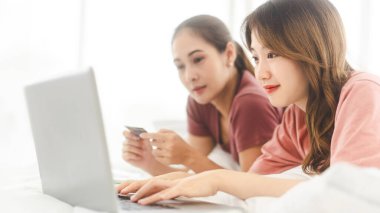 İlişki konseptiyle birlikte yaşayan iki yetişkin kadın. Doğru kişiye odaklan. Güneydoğu Asyalıların dostluğu yatak odasında uzanıyor ve sabahları iş hakkında konuşuyor..