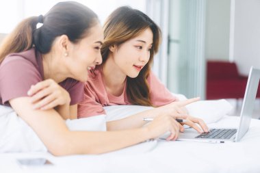 İlişki konseptiyle birlikte yaşayan iki yetişkin kadın. Doğru kişiye odaklan. Güneydoğu Asyalıların dostluğu yatakta uzanıyor ve sabahları konuşuyor..