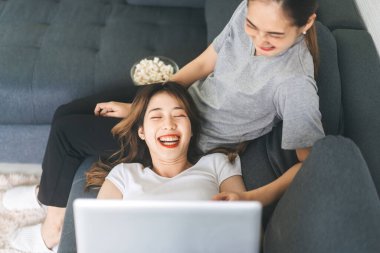 İlişki konseptiyle birlikte yaşayan iki yetişkin kadın. Güneydoğu Asyalı çiftler evlerinde ya da evlerinde patlamış mısır yiyerek rahat bir yaşam sürüyorlar..