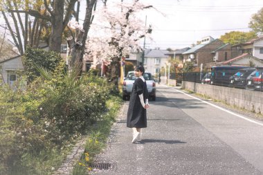 Kısa saçlı güzel Japon kadın portresi. Sakura ağacı arka planı. Doğa parkıyla Tokyo 'da rahatla..