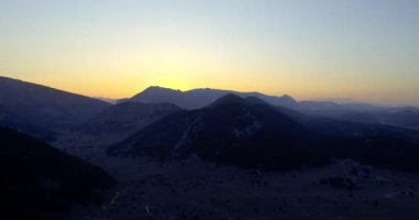 Dağların arasından gün batımı manzarası. Sinematik çekim