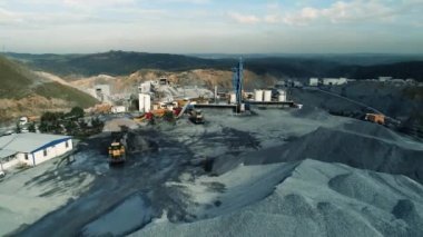 İnşaat alanında çalışan tekerlek yükleyicisinin hava görüntüsü. Tekerlekli buldozer toprağı kepçeyle dolduruyor..