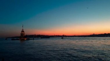 İstanbul, Türkiye 'de güzel gün doğumu olan bakireler kulesi, kiz kulesi. Arka planda şehrin ufuk çizgisi Boğaz suyuna yansıyor