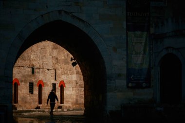 Karanlık yoldan aydınlığa doğru yürüyen adam. 25 Nisan 2023.