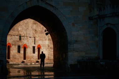 Karanlık yoldan aydınlığa doğru yürüyen adam. 25 Nisan 2023.