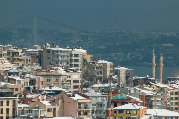 İstanbul kenti kışın karla kaplı evlerle manzaralı.