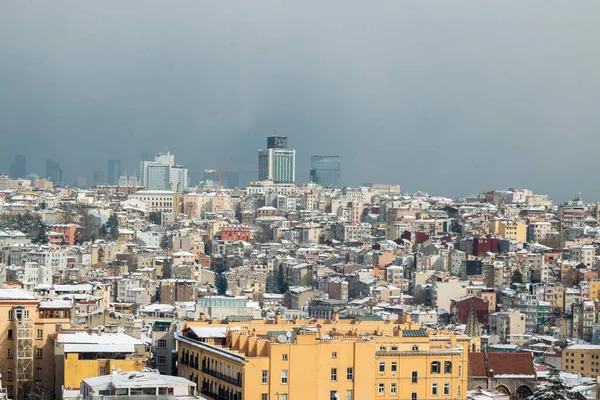İstanbul kenti kışın karla kaplı evlerle manzaralı.