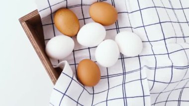  White and Brown Chicken Eggs in a Wooden Box. Chicken eggs are decorated in a minimal style.