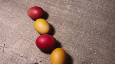 Painted easter eggs on a brown linen bedspread. Easter eggs. Red, brown and yellow chicken eggs.