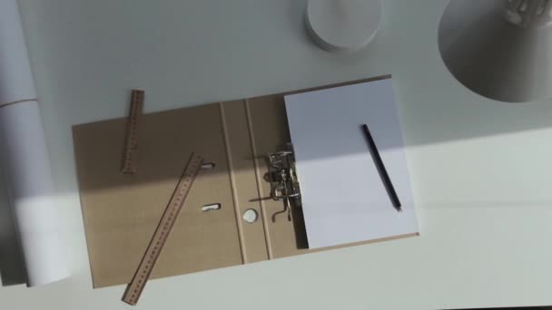 建筑师的白桌子上放着一本A4纸 铅笔和尺子的相册 — 图库视频影像