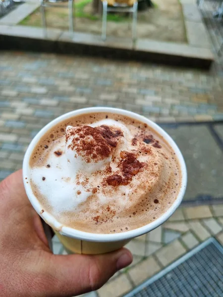 caffee in a cup with cacao foam in hand. High quality photo