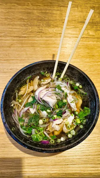 Pho Ga ChickEN Geleneksel Vietnam erişte çorbası. Yemek çubuklarıyla birlikte şifalı otlar. Yüksek kalite fotoğraf