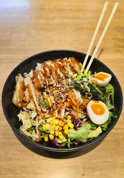 Büyük bir suşi kasesi, salata karışımı, avokado, fıstık, yosun salatası, kızarmış soğan, susam, lav proteini, mısır ve edamame. Yüksek kalite fotoğraf