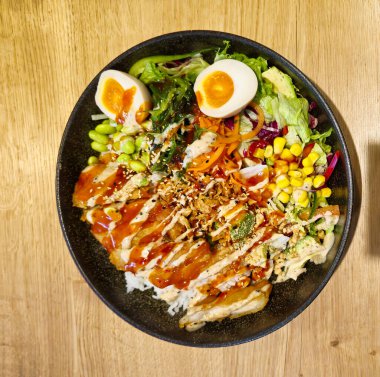 Büyük bir suşi kasesi, salata karışımı, avokado, fıstık, yosun salatası, kızarmış soğan, susam, lav proteini, mısır ve edamame. Yüksek kalite fotoğraf