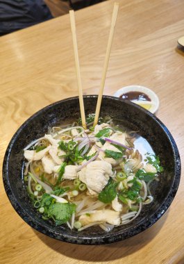 Pho Ga ChickEN Geleneksel Vietnam erişte çorbası. Yemek çubuklarıyla birlikte şifalı otlar. Yüksek kalite fotoğraf