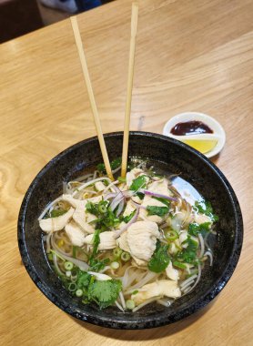 Pho Ga ChickEN Geleneksel Vietnam erişte çorbası. Yemek çubuklarıyla birlikte şifalı otlar. Yüksek kalite fotoğraf