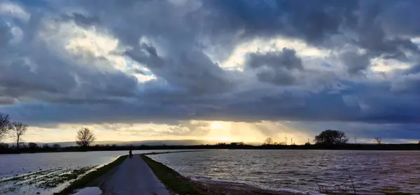 Kolenfeld wunstorf dirt road flooding with great cloudy sky and sunbeams germany. High quality photo